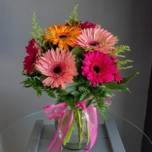 Ramo de gerberas de colores con flores rosadas y follaje verde