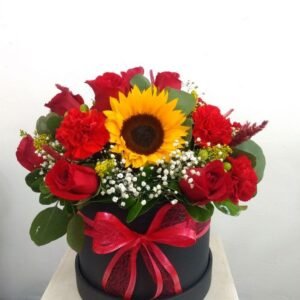 Caja de flores rojas con girasol y rosas